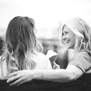 Friends sitting on bench having ice cream