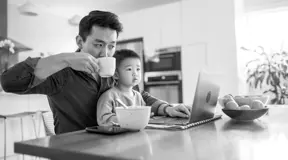 Dad on laptop with son on his lap 