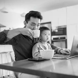 Dad on laptop with son on his lap