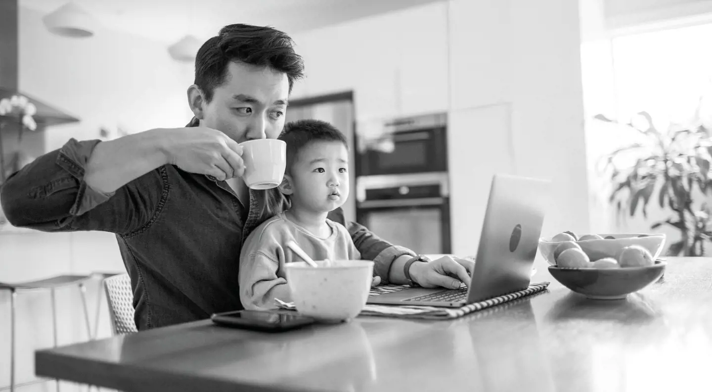 Dad on laptop with son on his lap 