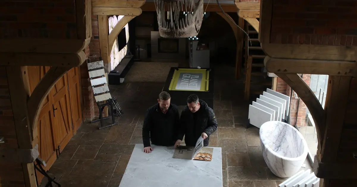 Two people in the Planet Granite showroom browsing a magazine.