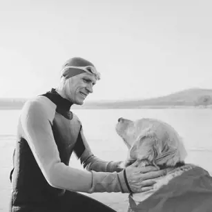 Person and golden retriever at beach