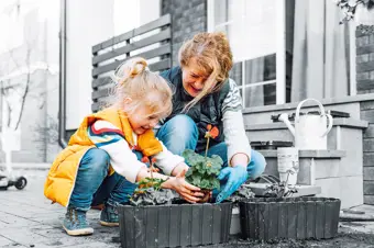 Child and grandmother planting flowers