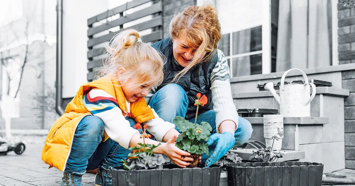 Child and grandmother planting flowers