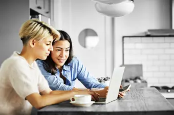 Two people looking at something on a laptop