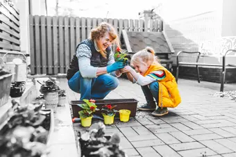 Child and grandparent planting flowers