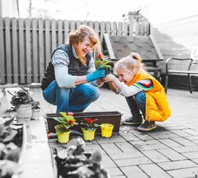 Child and grandparent planting flowers