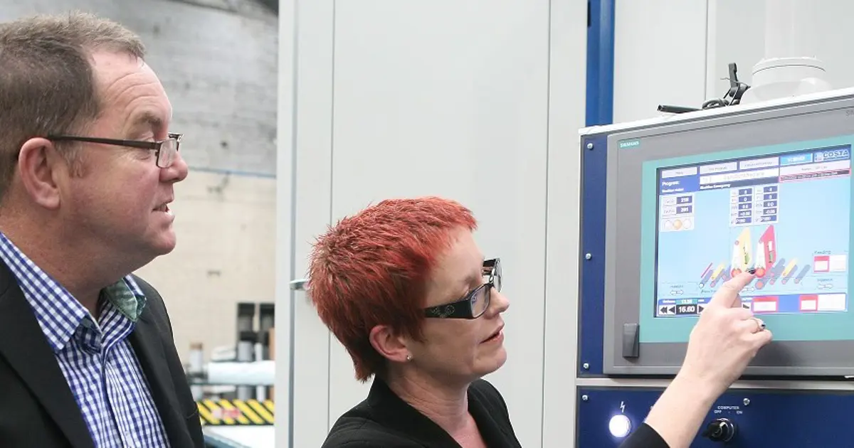 Two people from Professional Polishing Services using the screen on one of their machines.