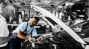 Two mechanics working on a car