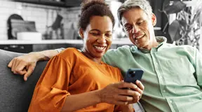 Smiling couple looking at something on a phone
