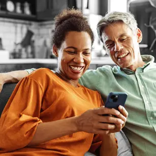 Smiling couple looking at something on a phone