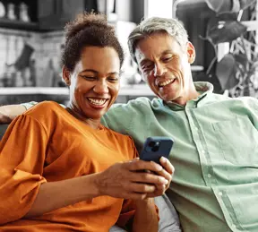 Smiling couple looking at something on a phone