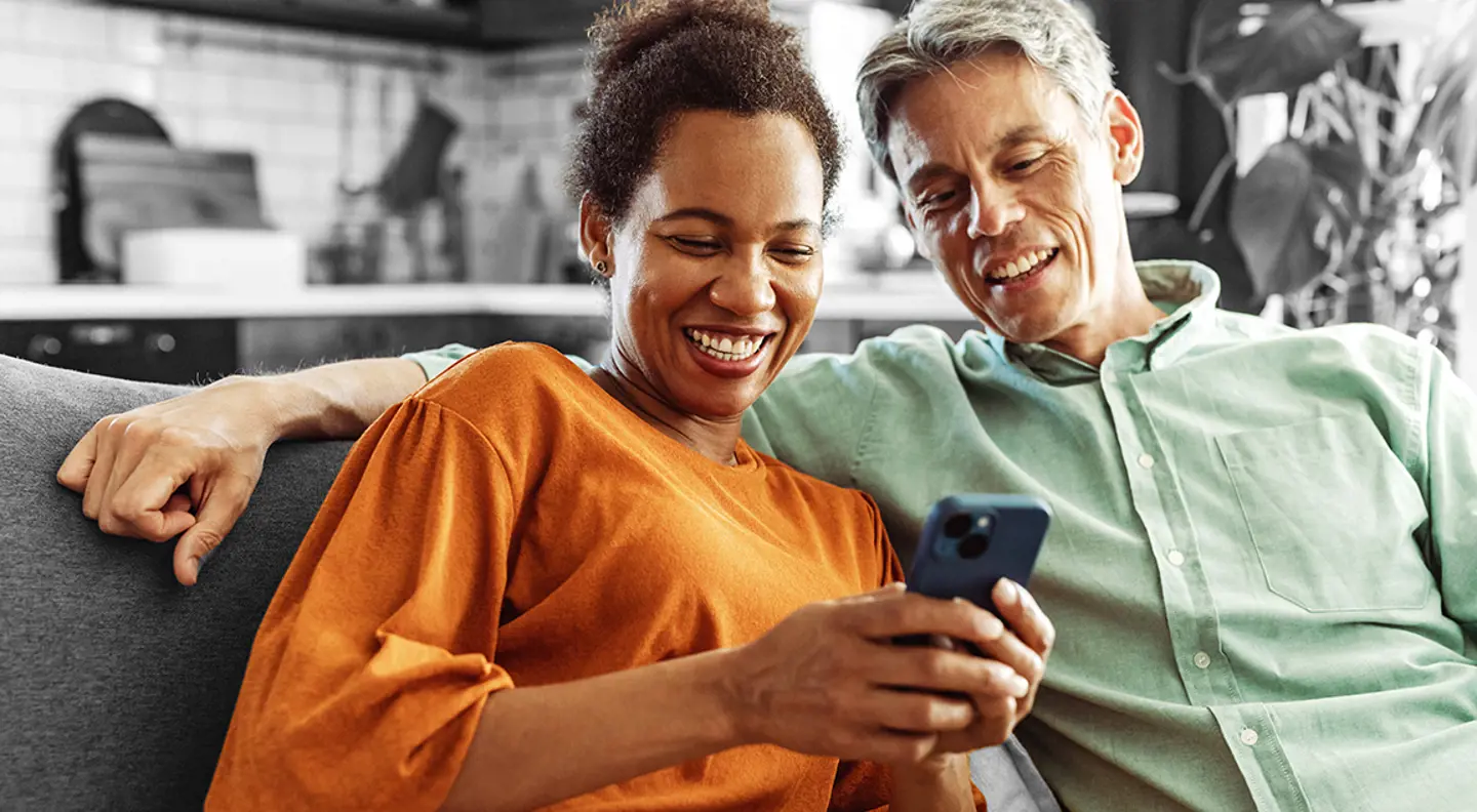 Smiling couple looking at something on a phone