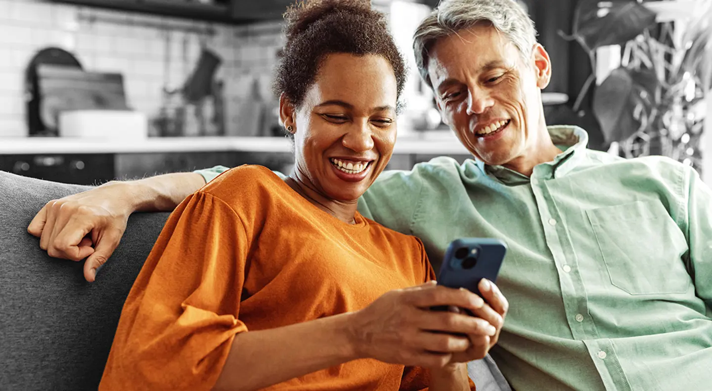 Smiling couple looking at something on a phone