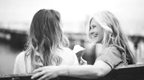 Friends sitting on bench having ice cream