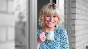 Smiling person drinking a cup of tea