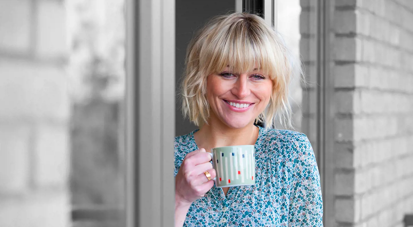 Smiling person drinking a cup of tea