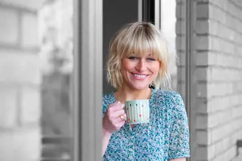 Smiling person drinking a cup of tea