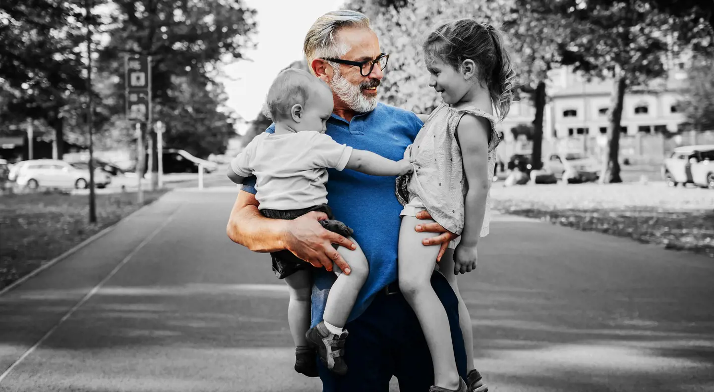 Grandad holding grandkids in the street