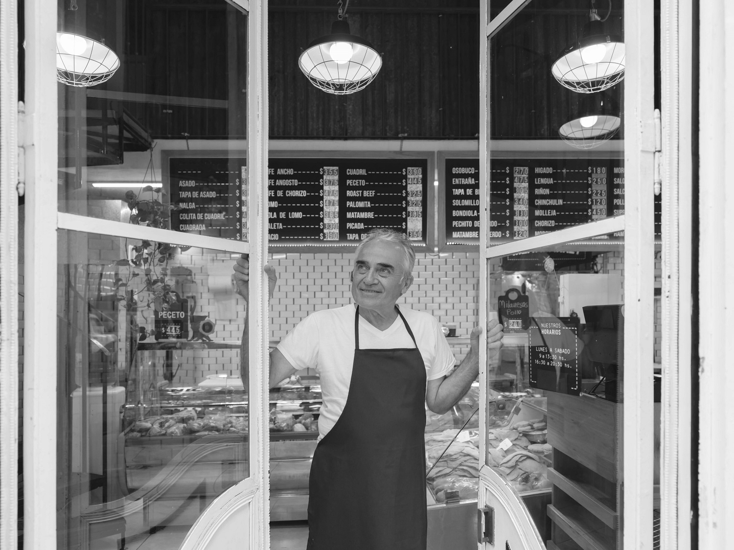 Business owner looking out of shop window 