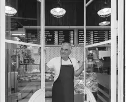 Business owner looking out of shop window 