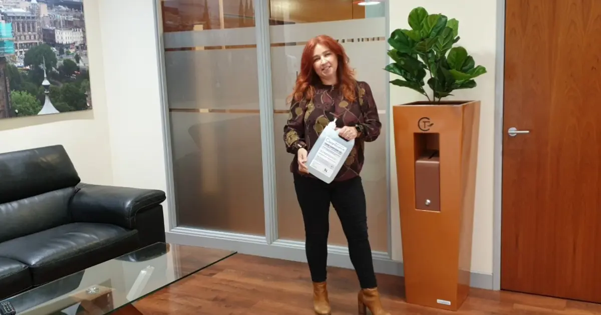 Karen Sawyer of Livingreen Design standing in the office next to a plant pot.