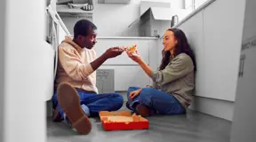 First time buyers eating pizza on floor 
