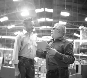 Colleagues talking at factory
